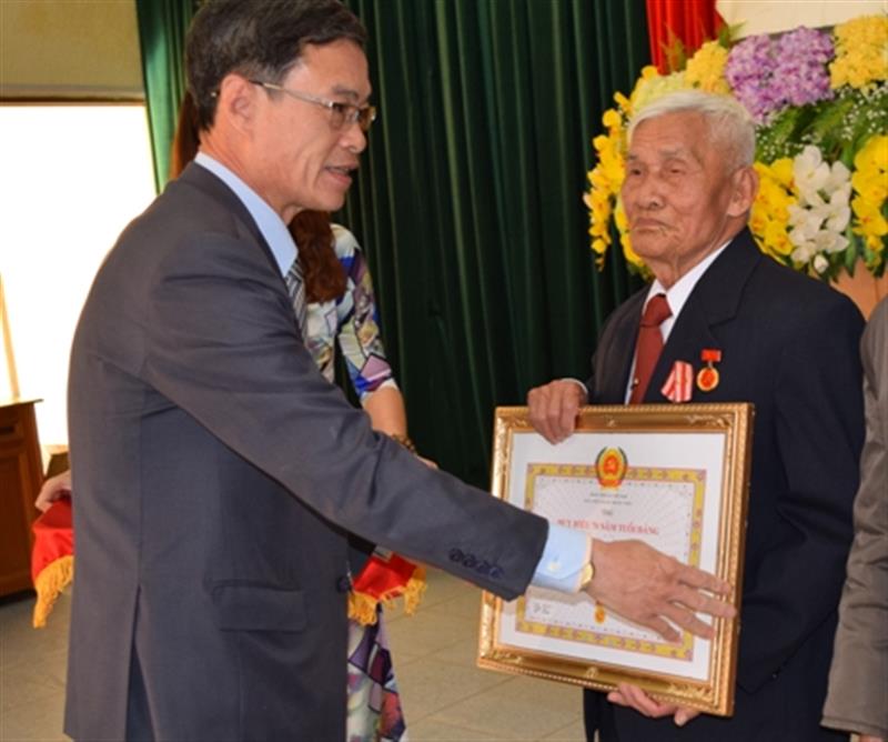 Đ/c Trần Duy Hùng – UVBTV Tỉnh ủy, Trưởng Ban tổ chức Tỉnh ủy trao Huy hiệu 70 năm tuổi Đảng cho đảng viên lão thành Lê Đạo